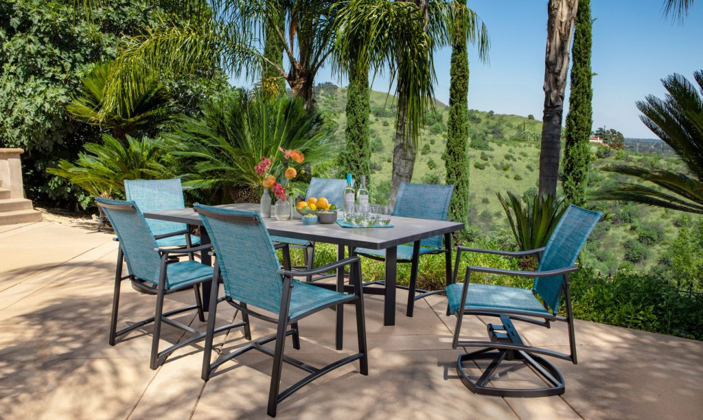 Outdoor dining set with a teal and gray color scheme, set on a patio with a scenic view.