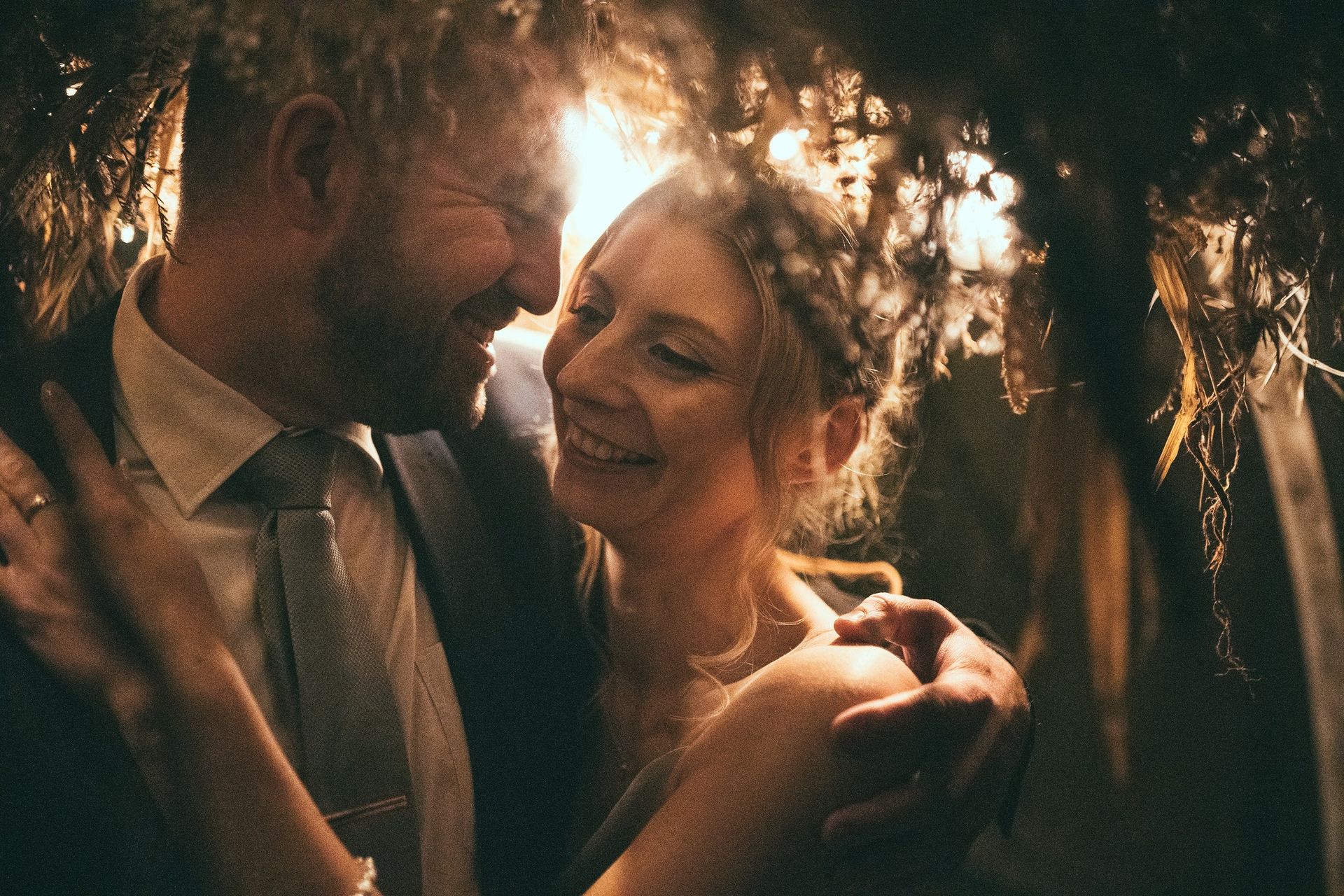 A man and a woman are looking at each other in a dark room.
