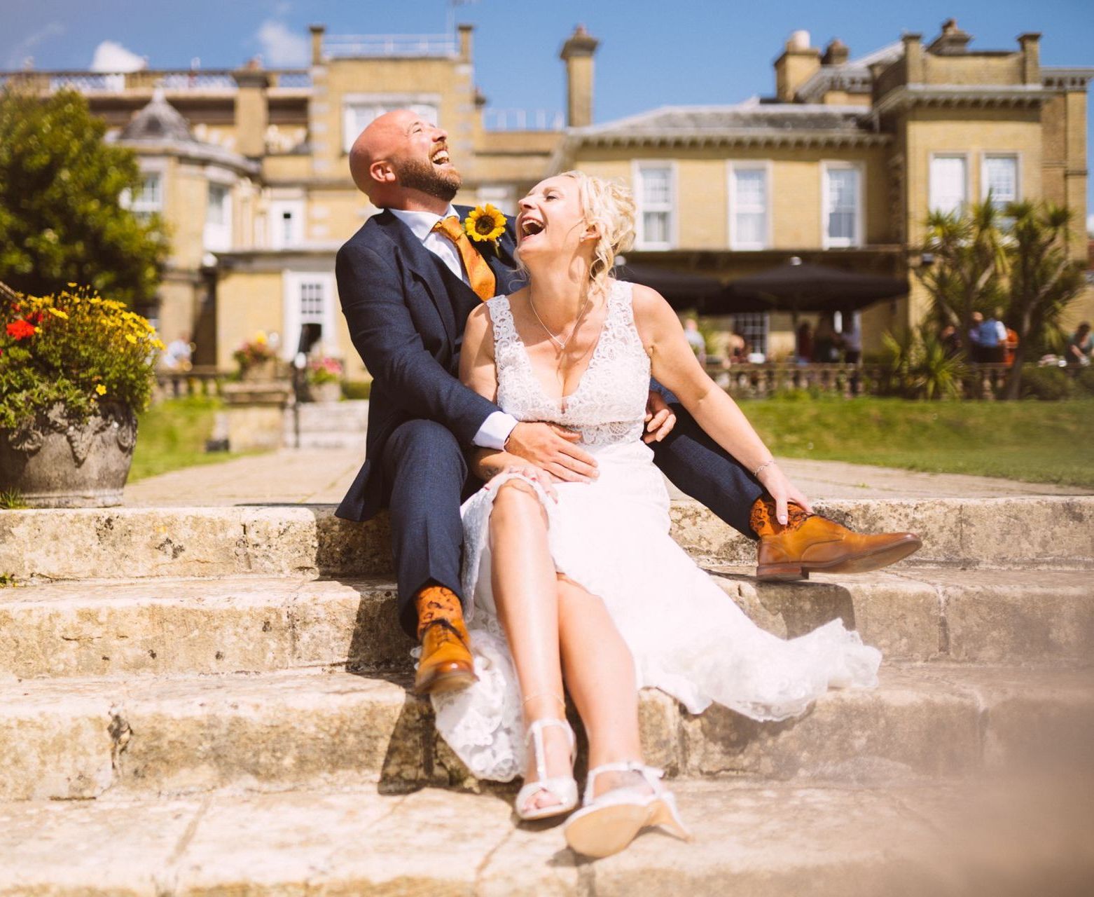 A bride and groom are sitting on the steps of a building.
