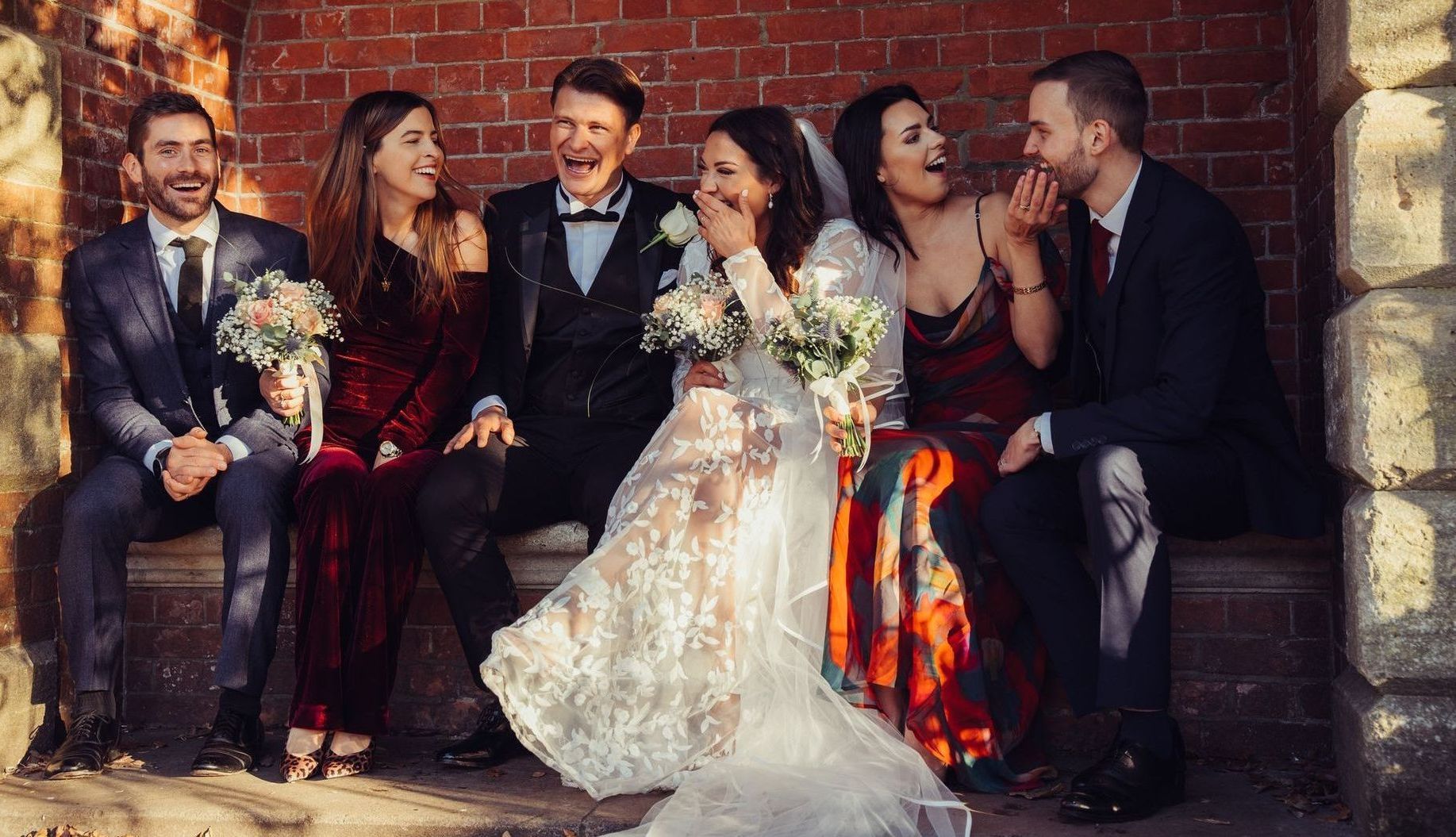 A bride and groom are posing for a picture with their wedding party.