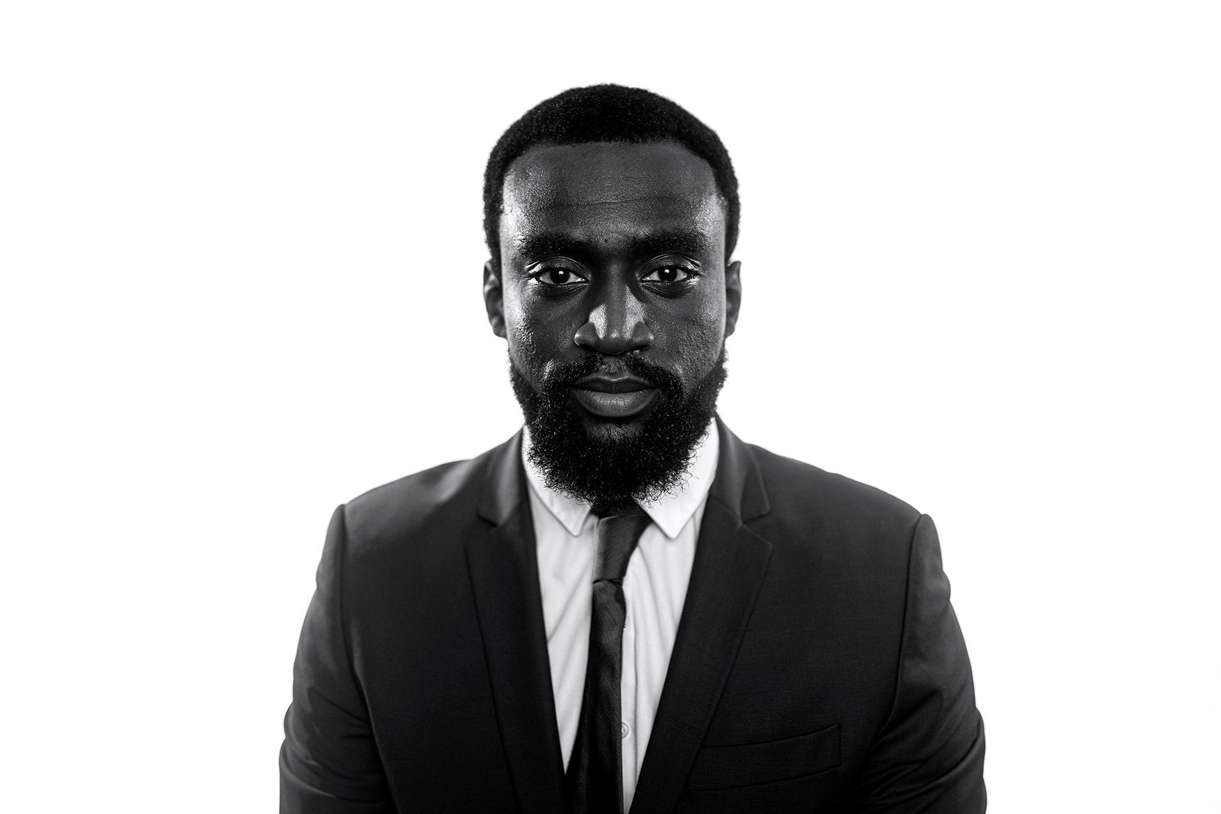 A black and white photo of a man in a suit and tie.