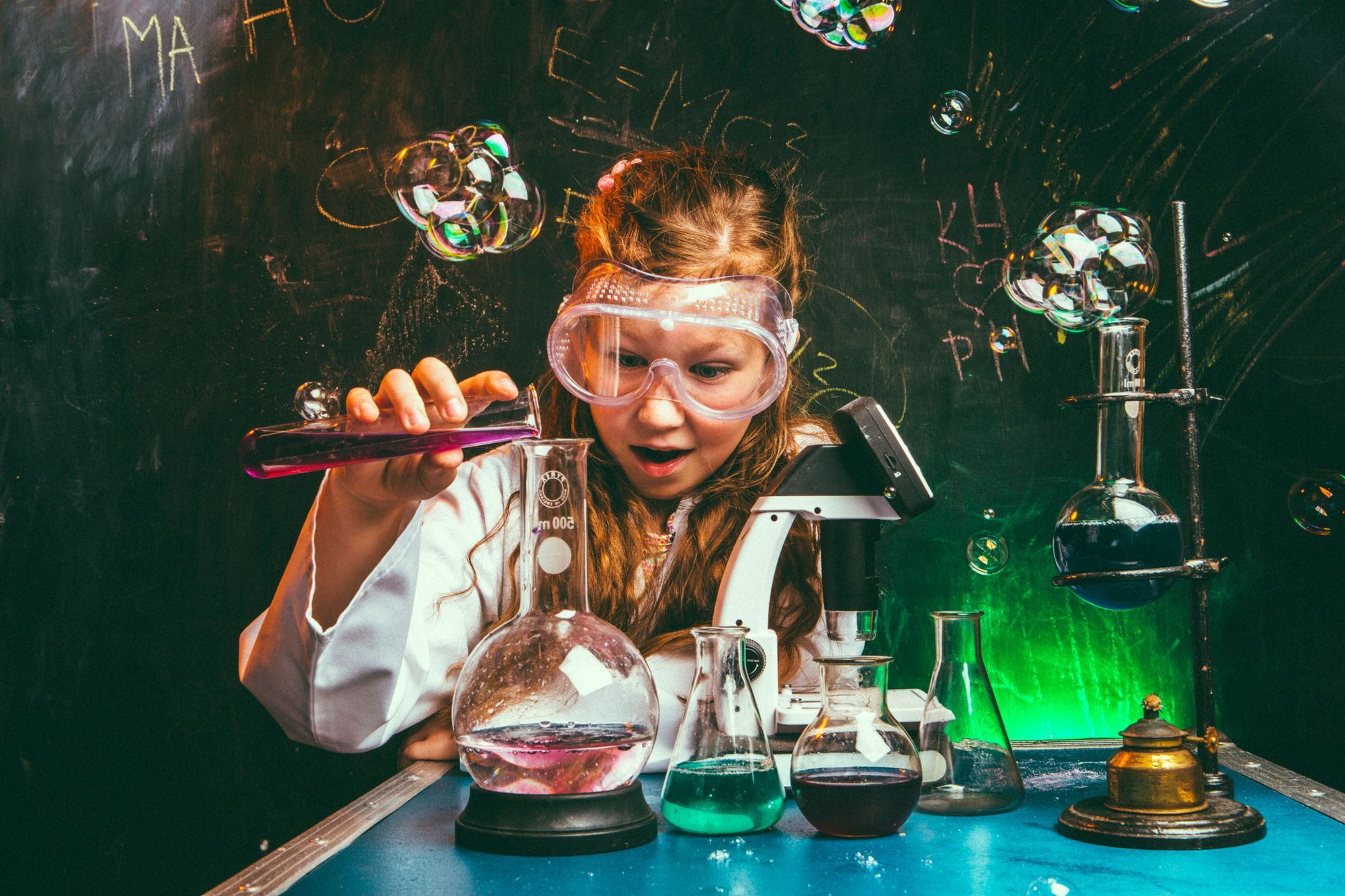 A young girl is making a chemical experiment in a lab.