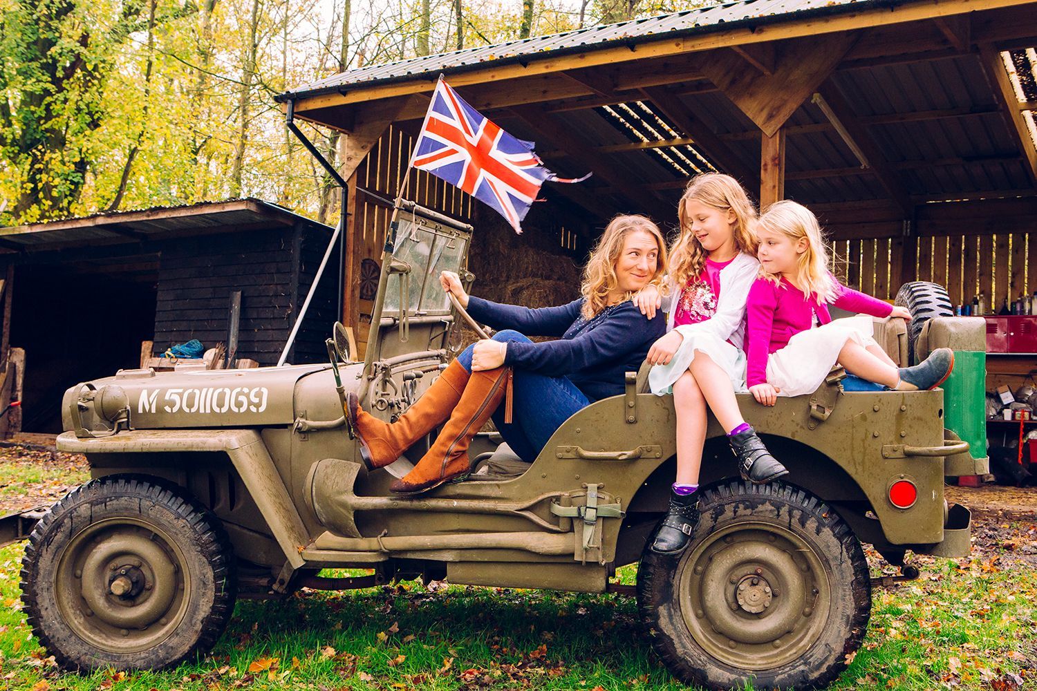 A group of people are sitting in a jeep with a british flag.
