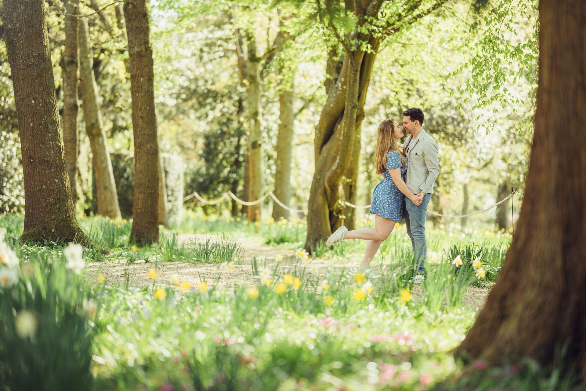 A man and a woman are holding hands in a forest.