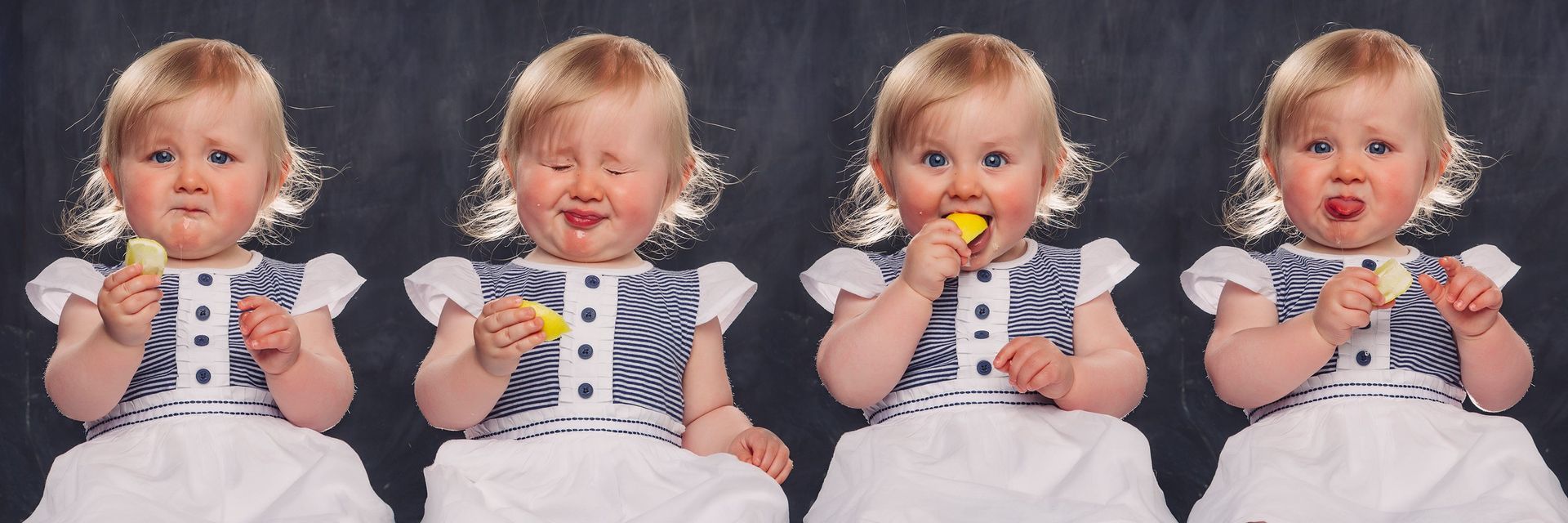 Four little girls in white dresses are eating lemons