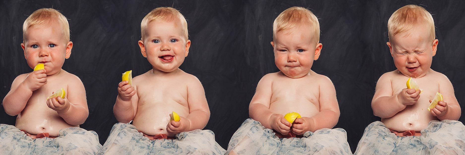 A baby in a tutu is eating a lemon.