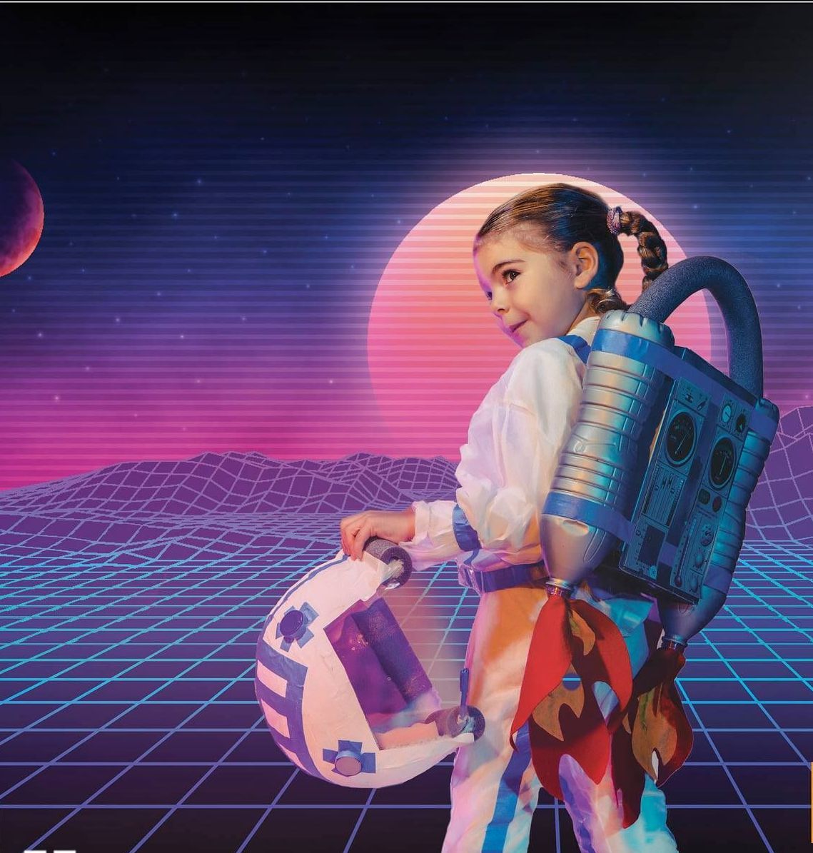 A little girl in an astronaut costume is holding a helmet.
