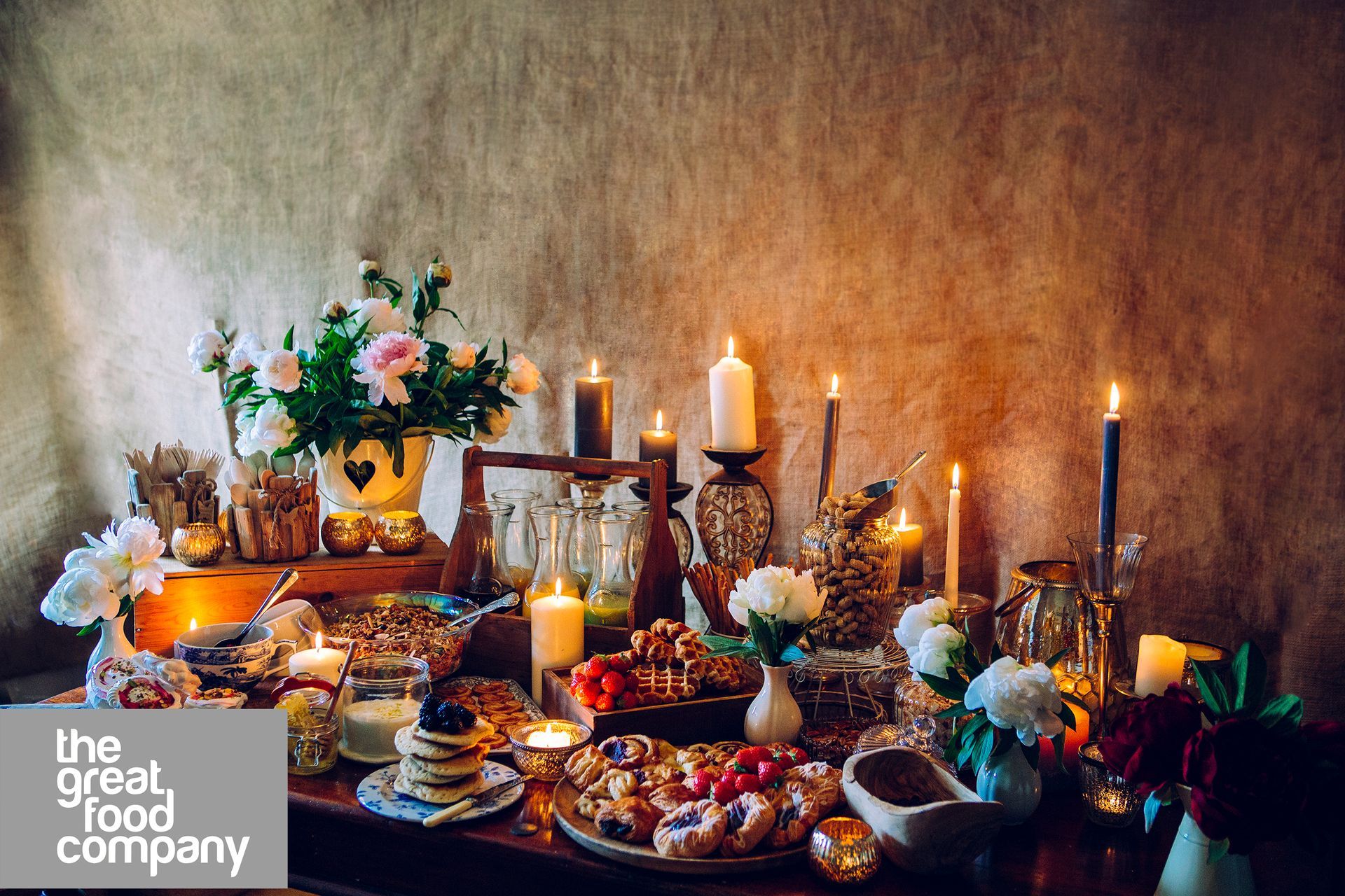 A table with a lot of food and candles on it.