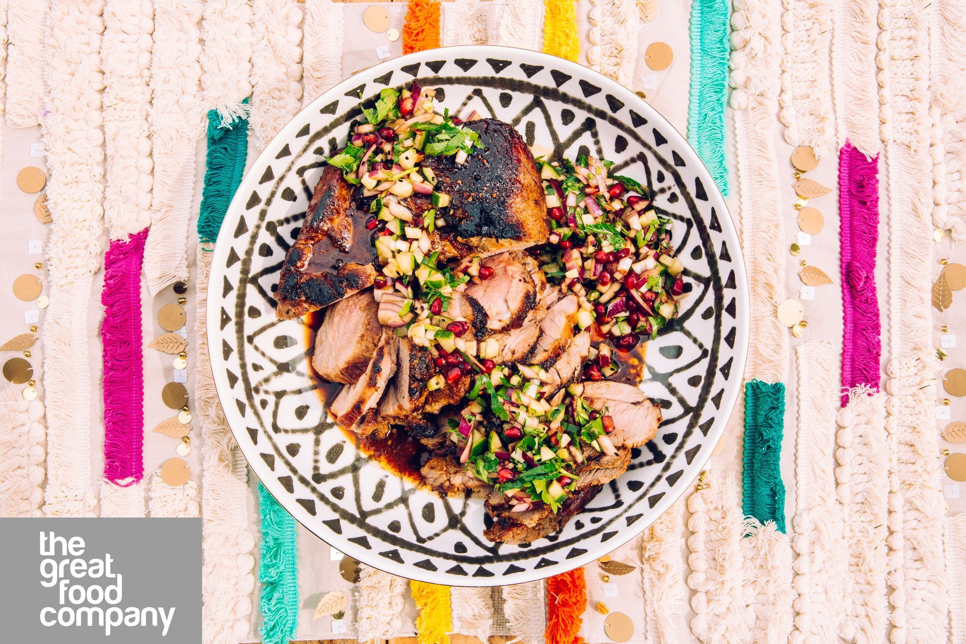 A plate of food is sitting on a colorful table cloth.