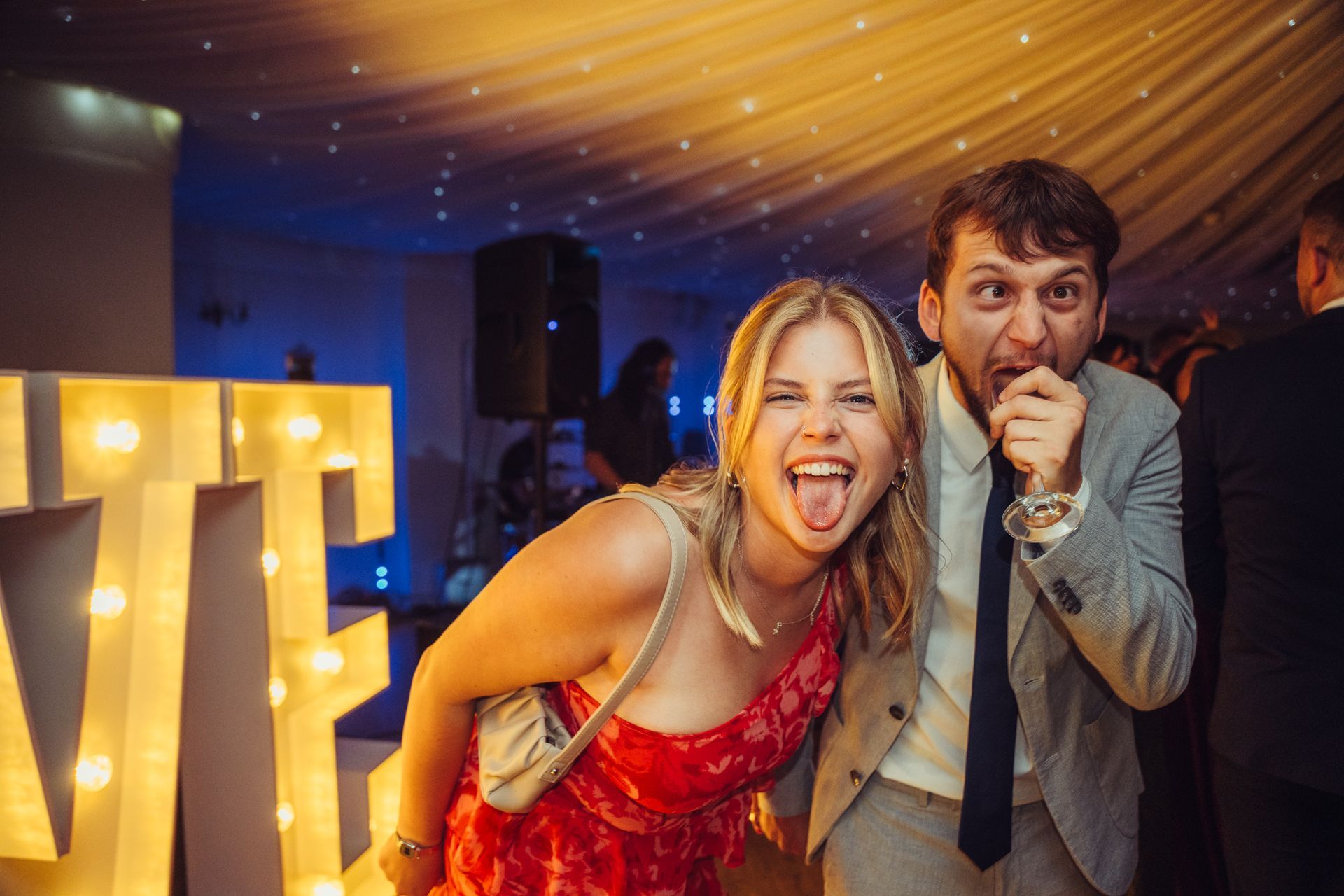 A man and a woman are posing for a picture at a party.
