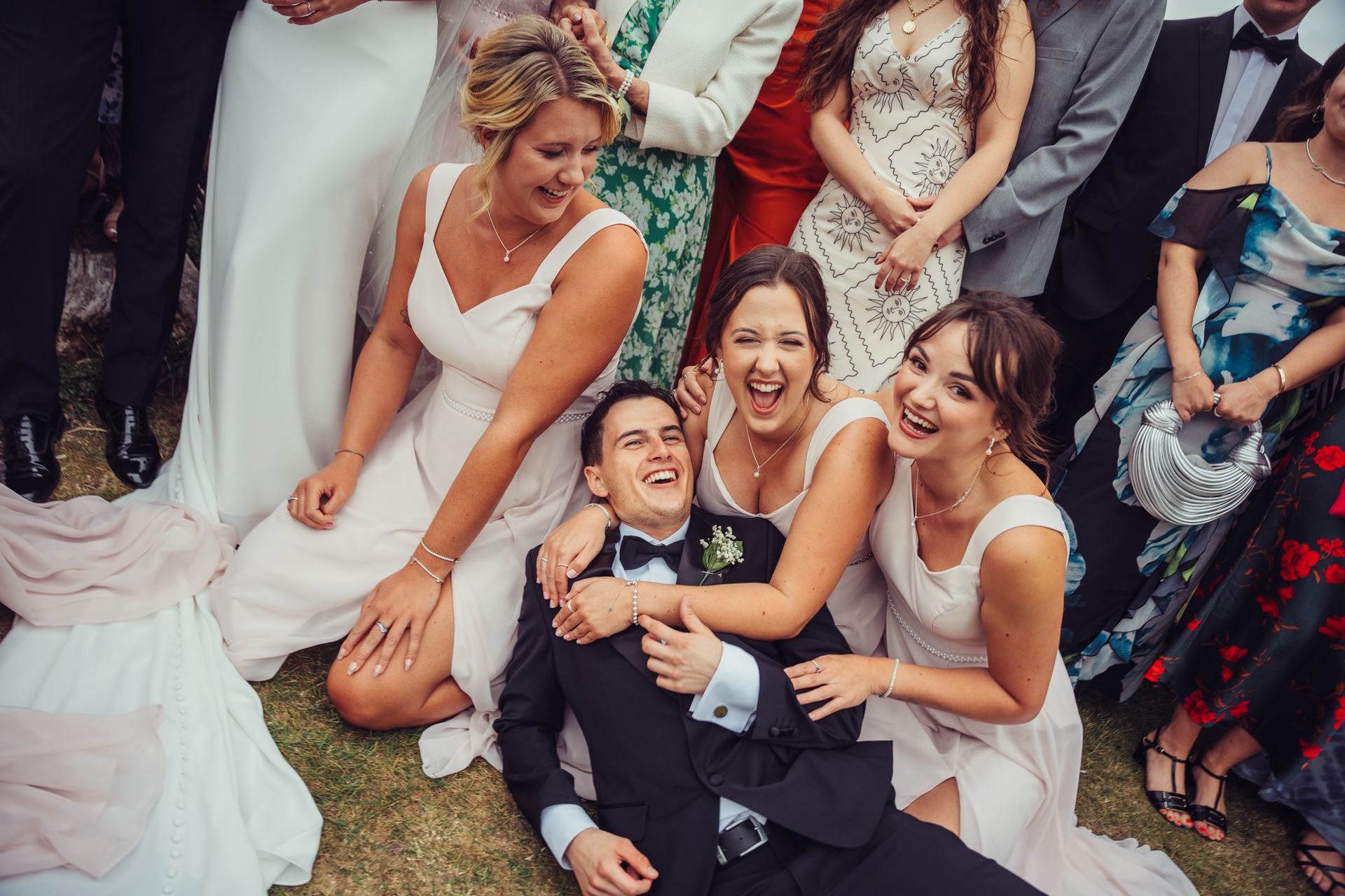 A bride and groom are posing for a picture with their wedding party.