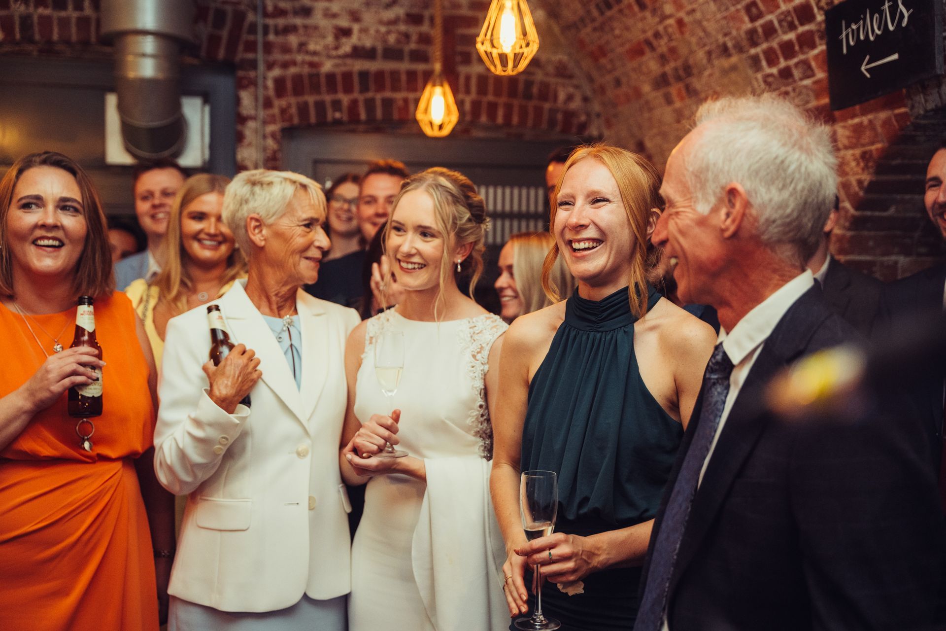 A group of people are standing next to each other at a wedding reception.