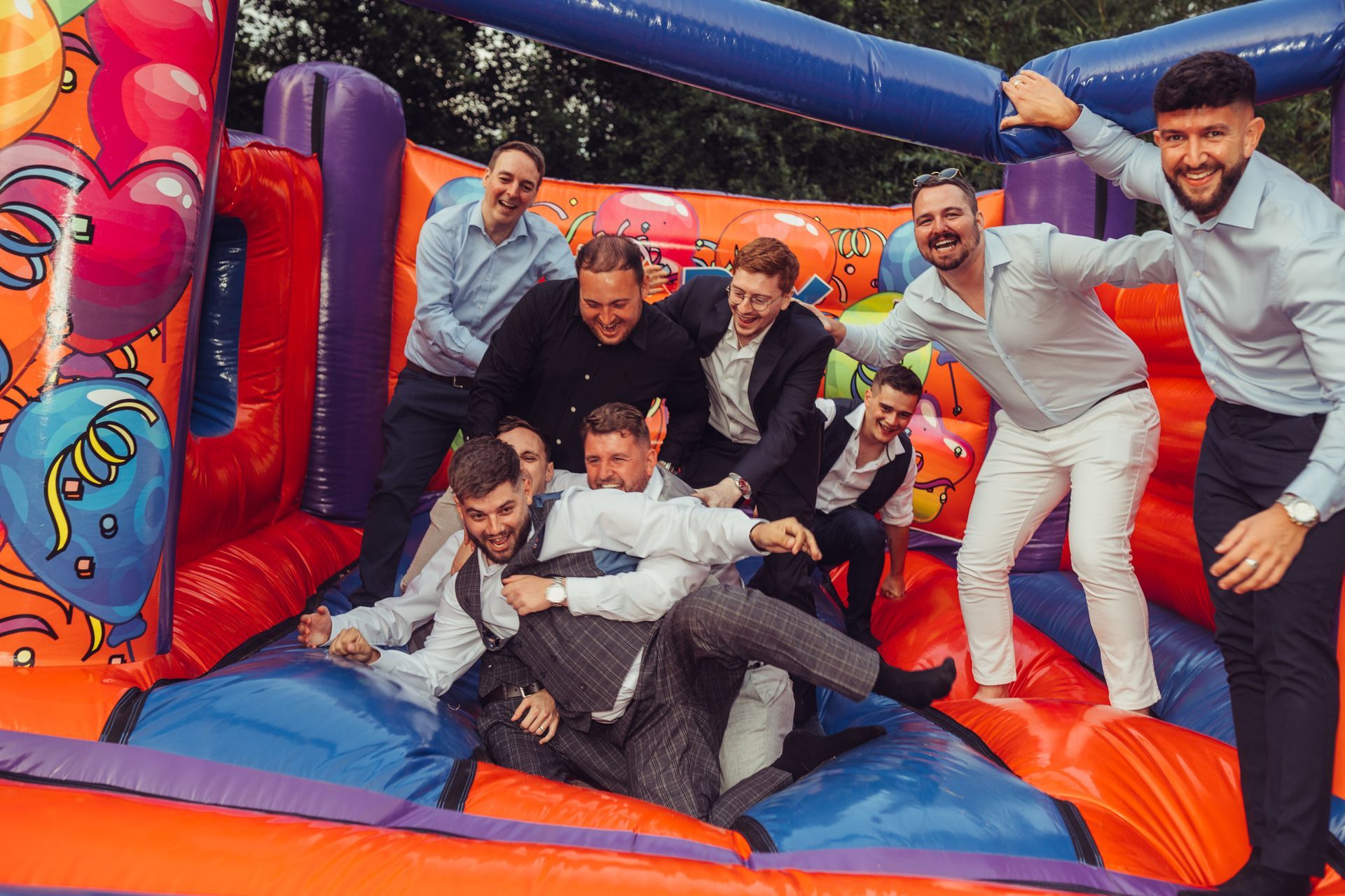 A group of men are playing in an inflatable bouncy house.