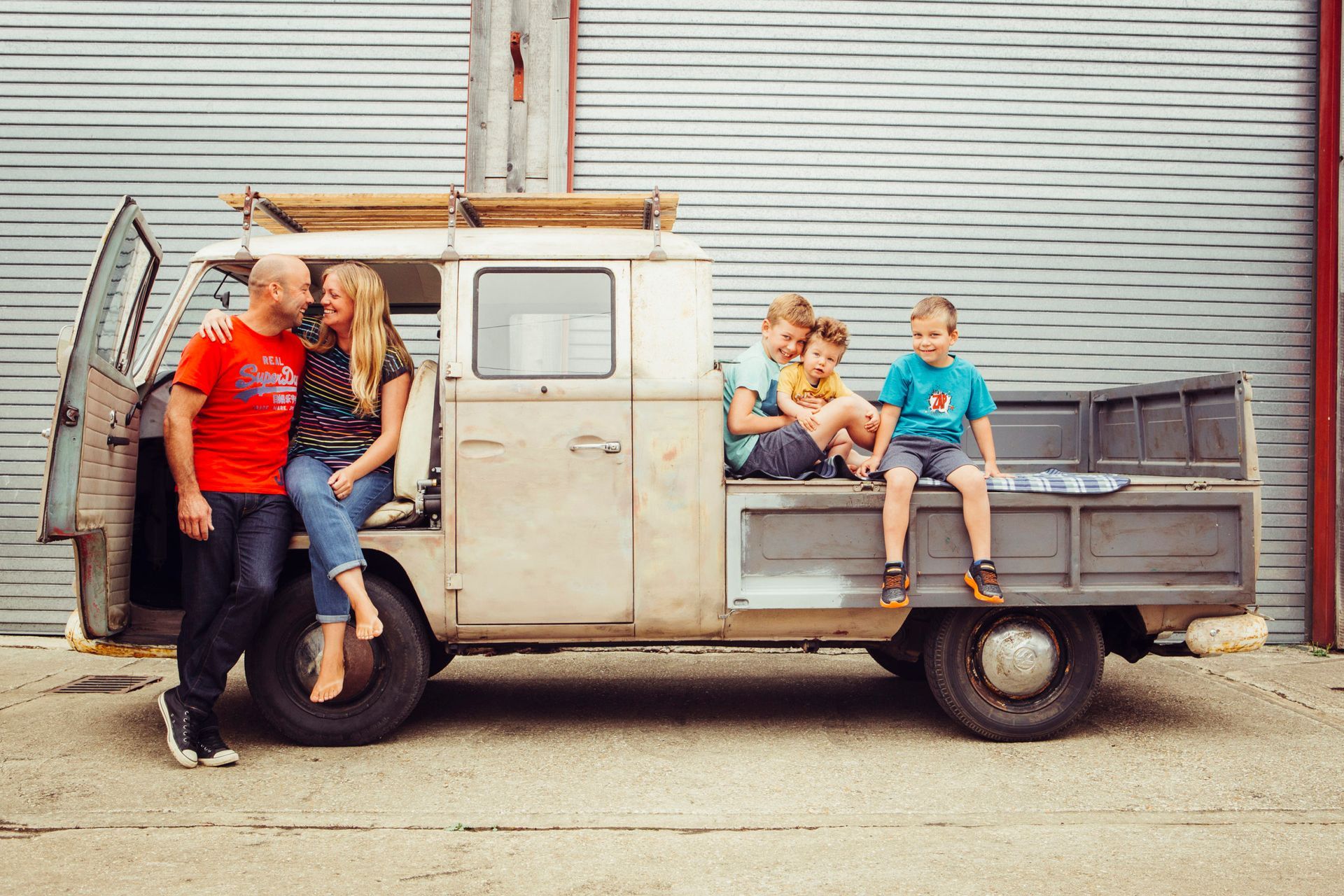 A family is sitting in the back of a truck.