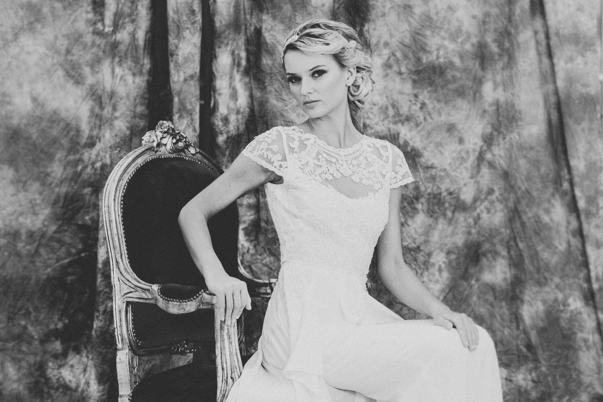 A woman in a wedding dress is sitting in a chair.