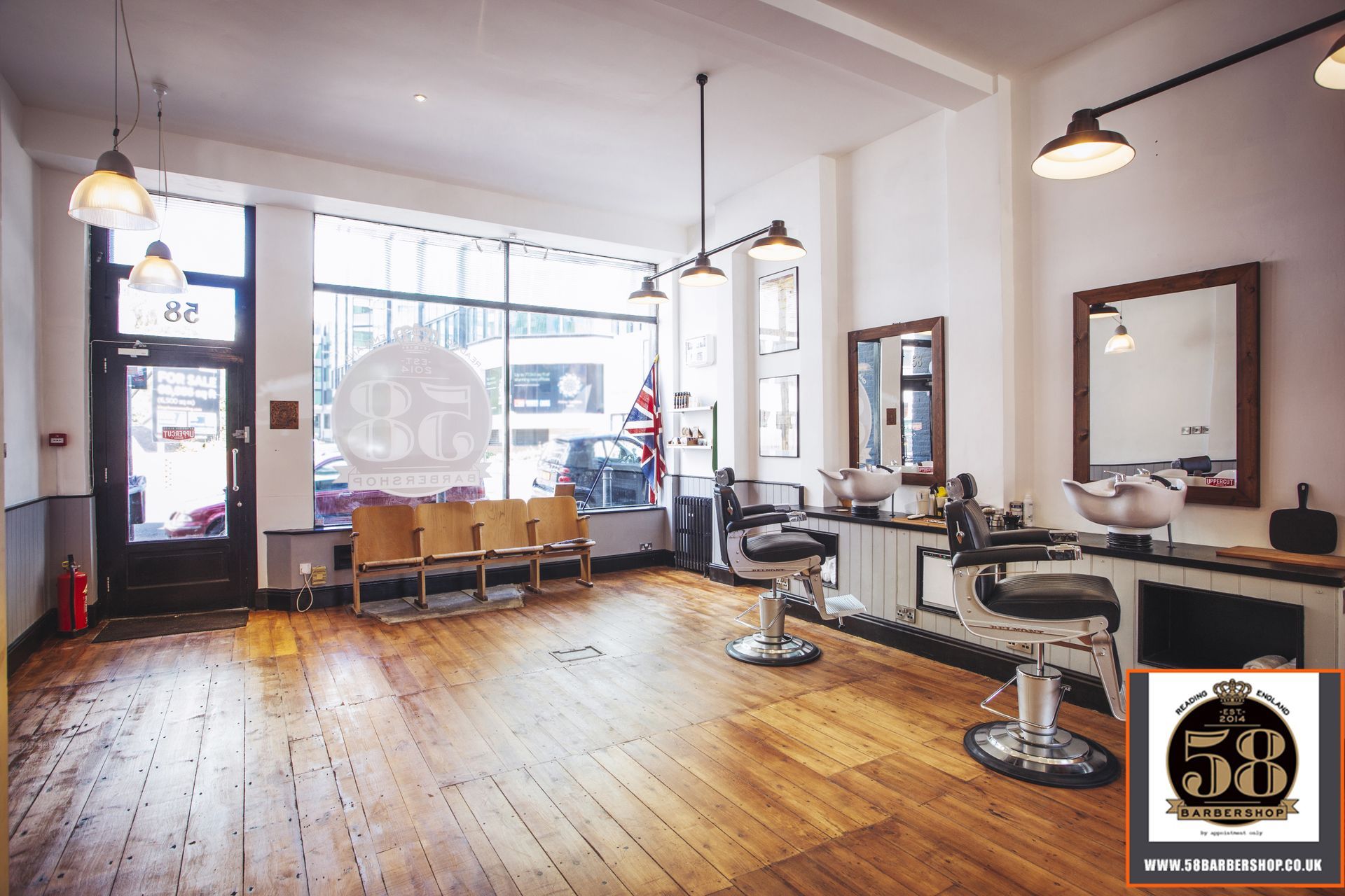 The inside of a barber shop with wooden floors and chairs