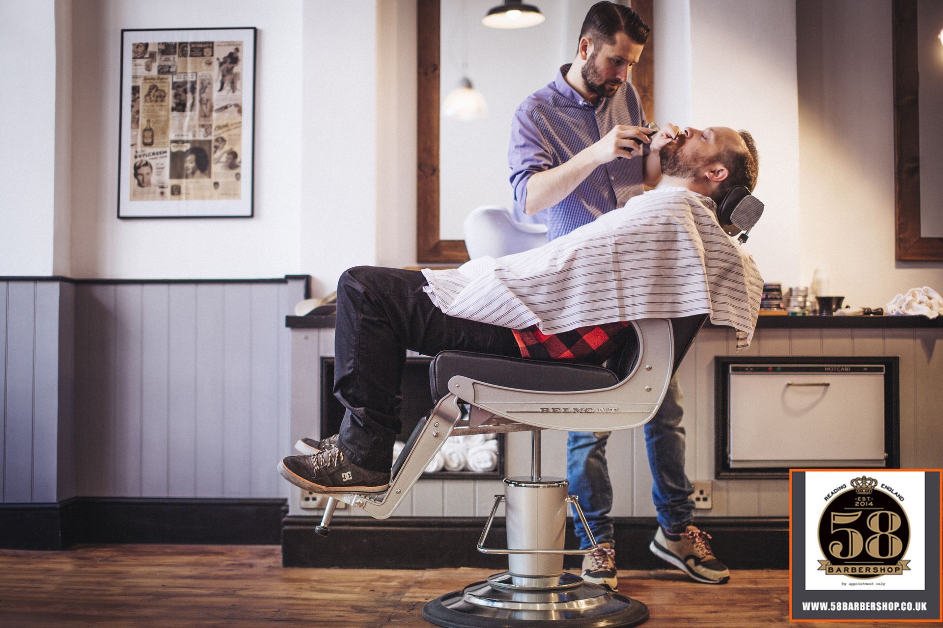 A man is getting his beard shaved by a barber in a barber shop.