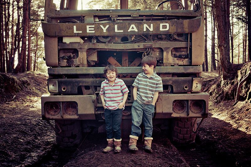 Two young boys standing in front of a leyland truck