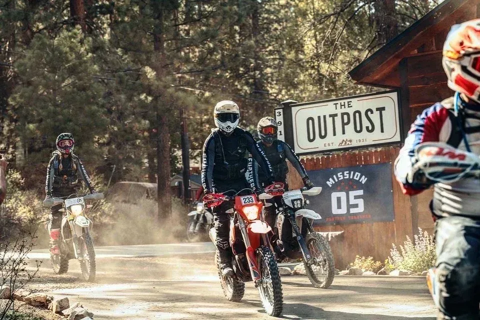 Dirt bikers riding on a dirt road toward 