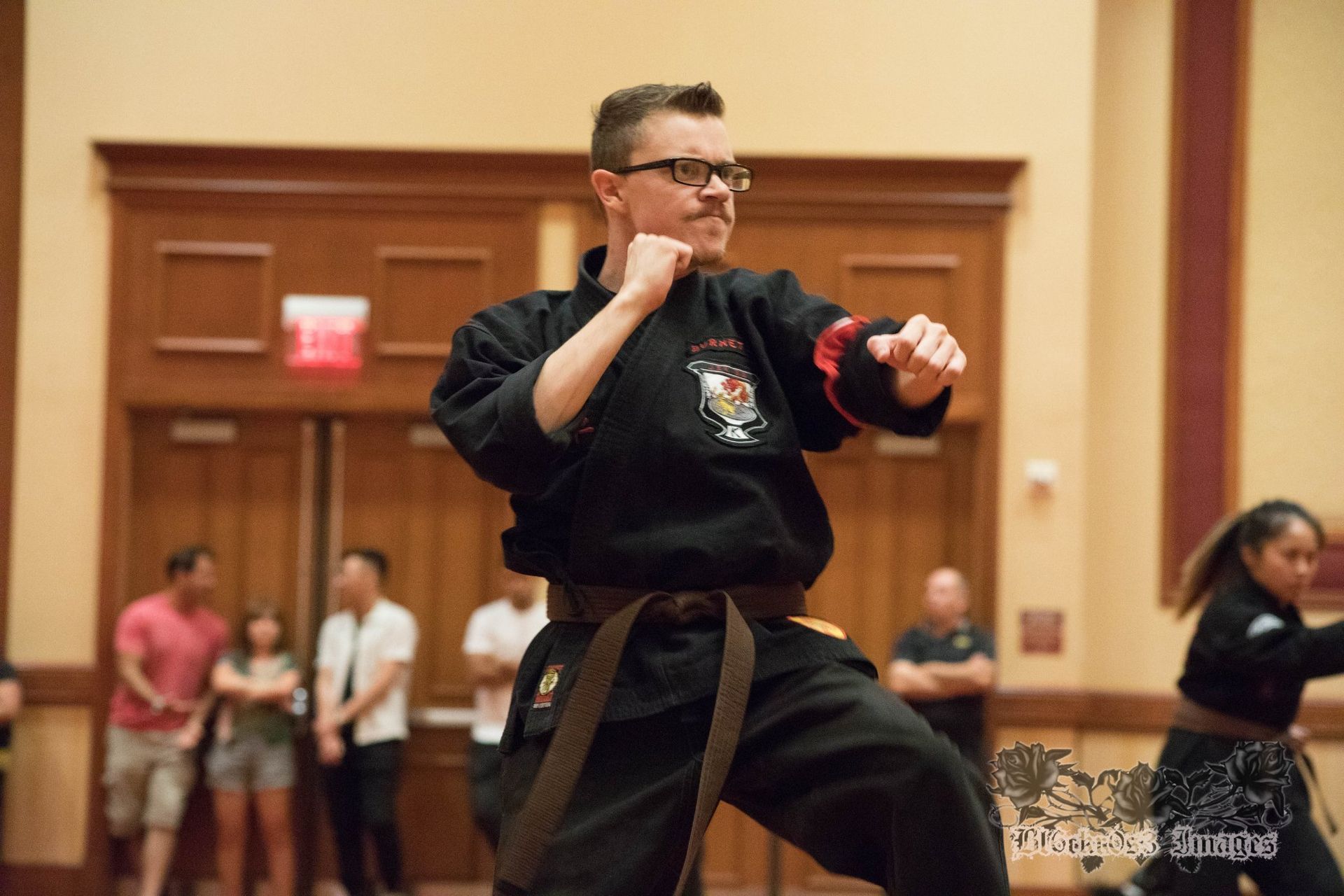 Two men in karate uniforms are posing for a picture in a gym.