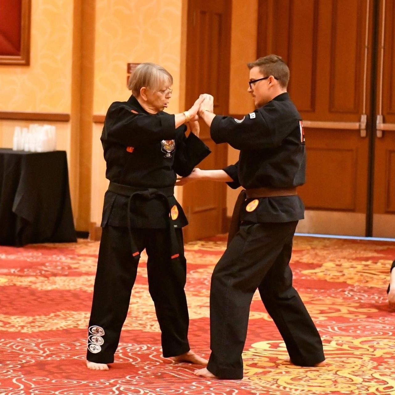 Two young men are practicing karate on a mat