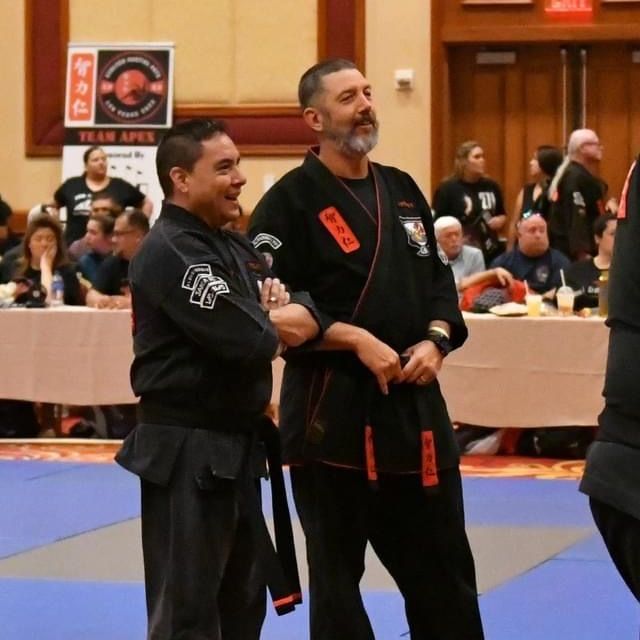 A group of men are practicing karate in a gym.