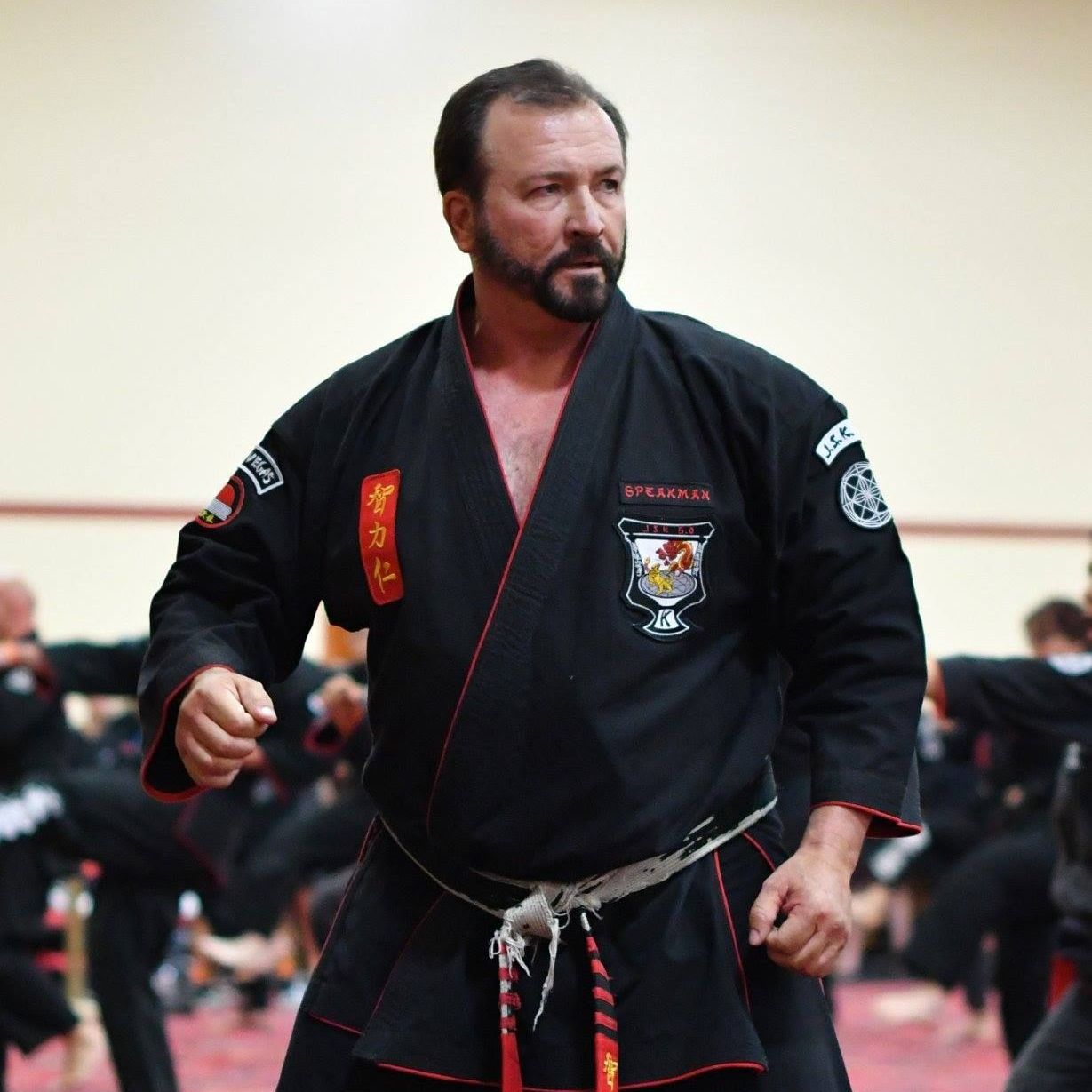 A group of men are practicing karate in a gym.