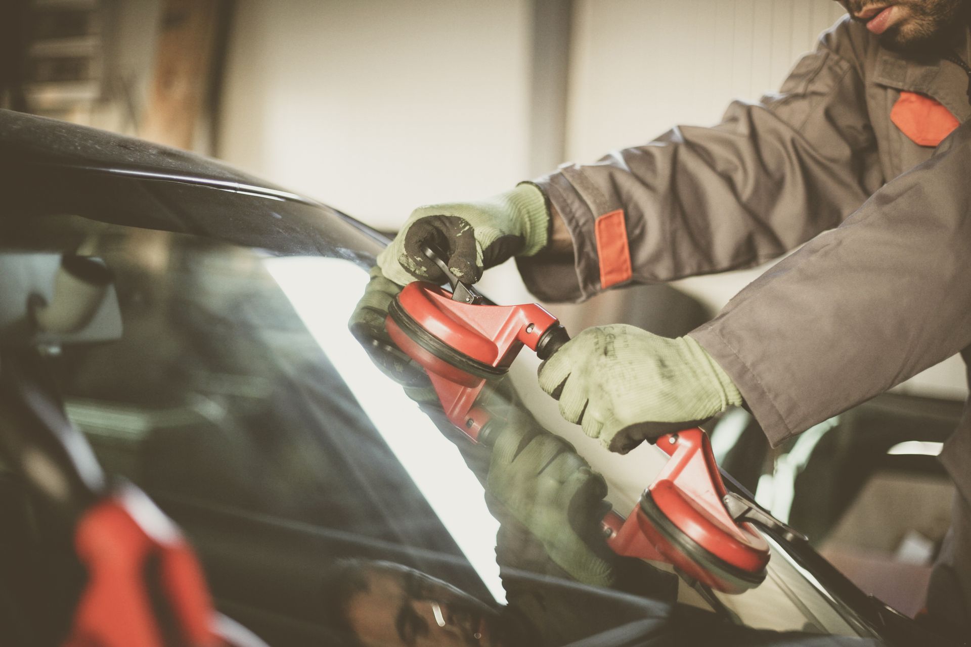 A man is fixing a broken windshield on a car.