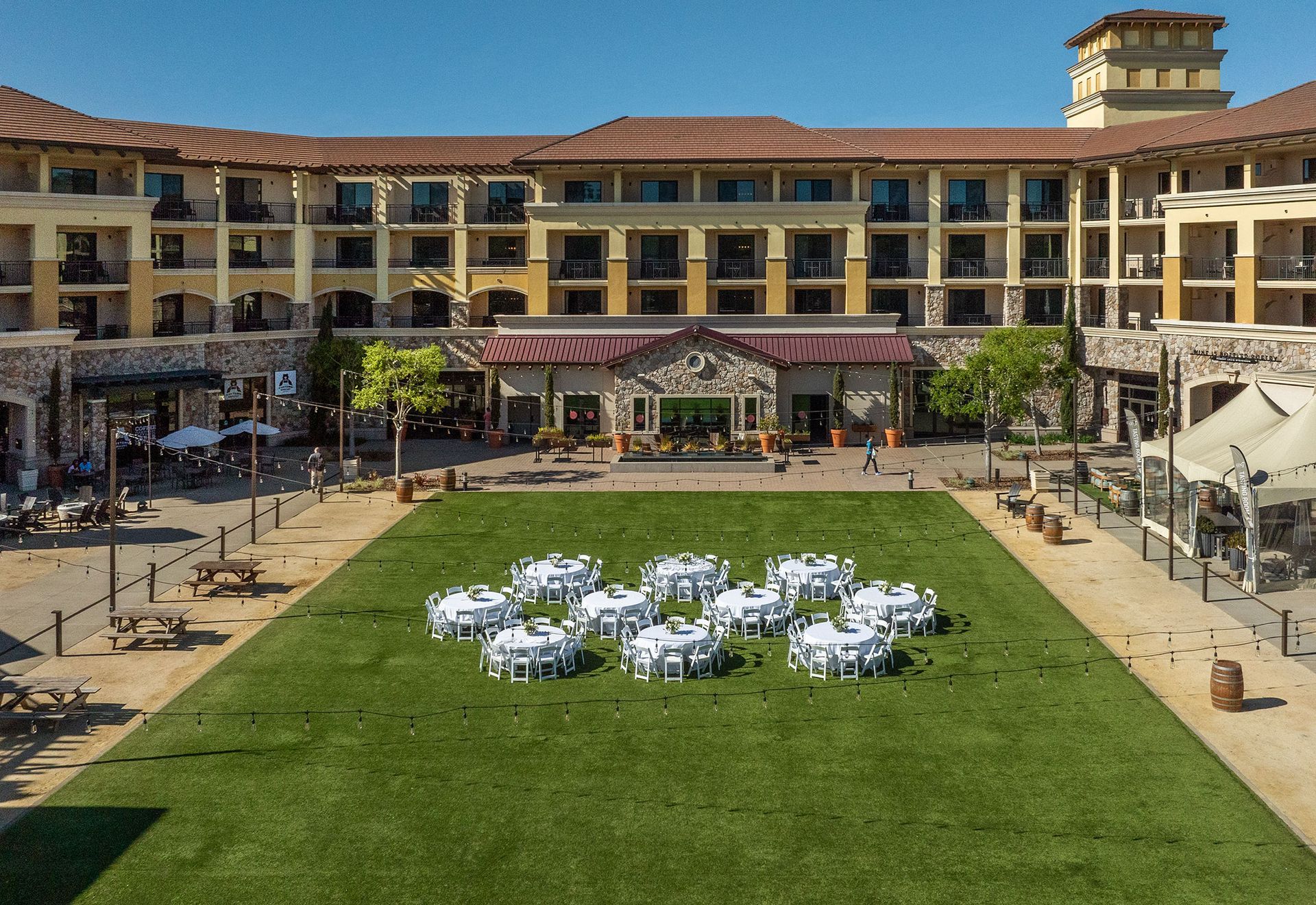 Hotel courtyard with green lawn and white chairs arranged in a circle