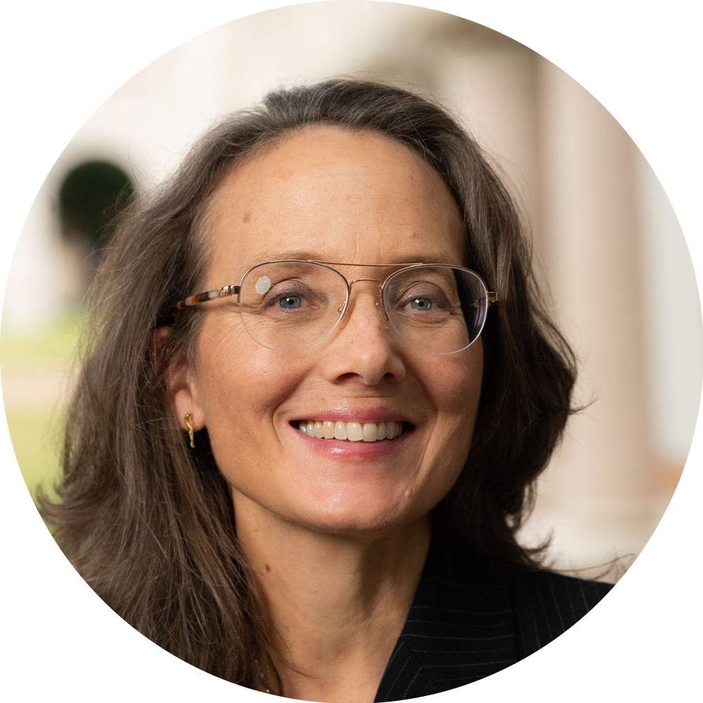 Smiling woman with glasses in a softly blurred indoor setting