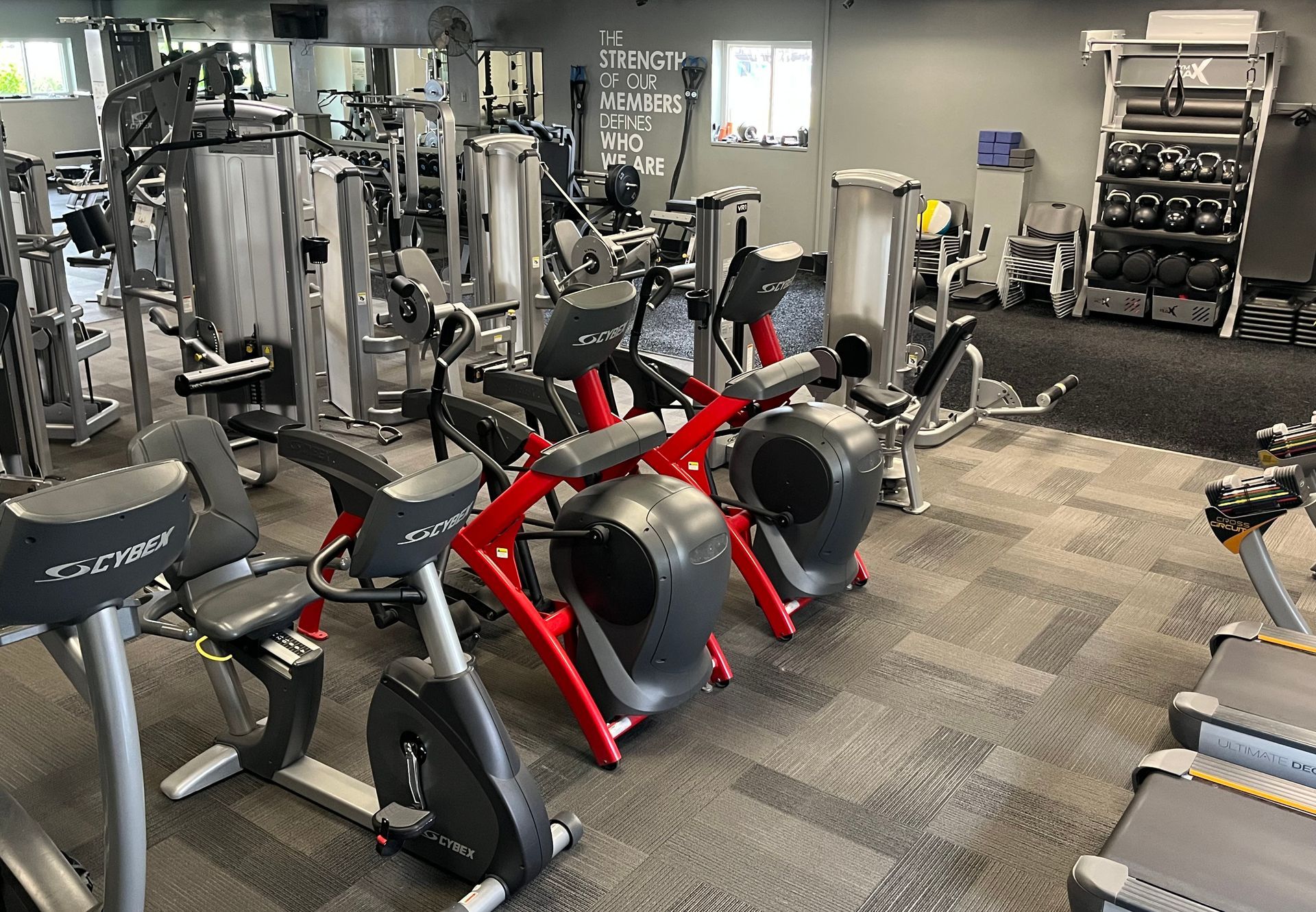 A gym filled with lots of exercise equipment and a treadmill.