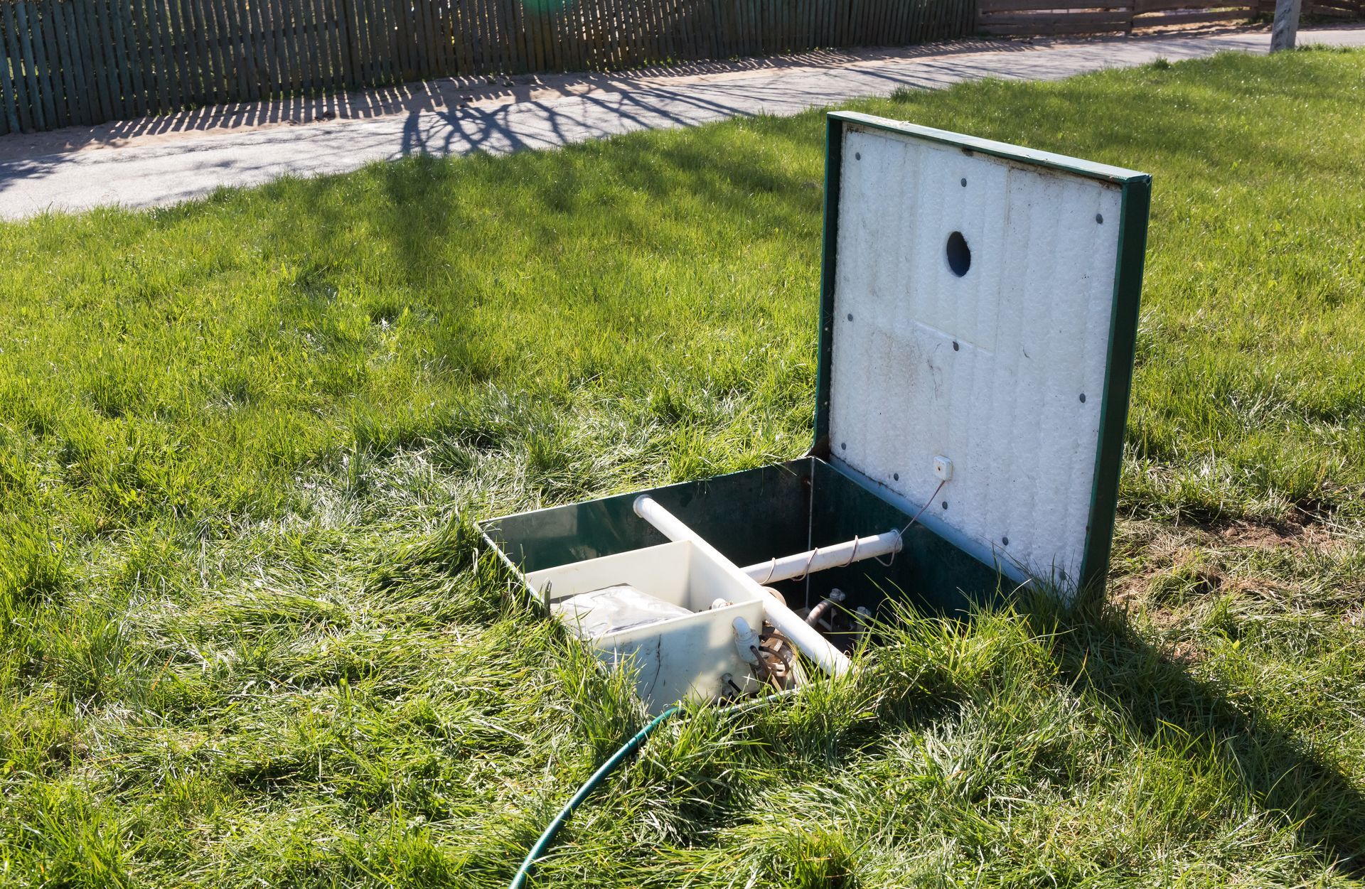 Open septic tank access lid in a Garner, NC yard ready for septic pumping service Open septic tank access lid in a Garner, NC yard ready for septic pumping service