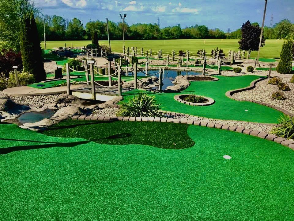 A mini golf course with a bridge in the middle of it.