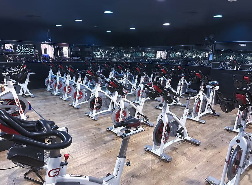 Indoor spin studio with rows of stationary bikes under dim lighting