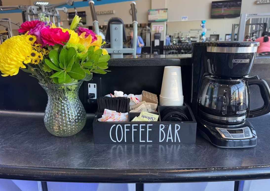 Coffee bar with a vase of colorful flowers and a coffee maker on a counter