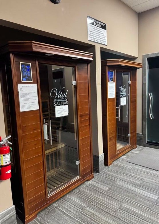 Two wood-framed glass office doors in a hallway with a carpeted floor and red fire extinguisher