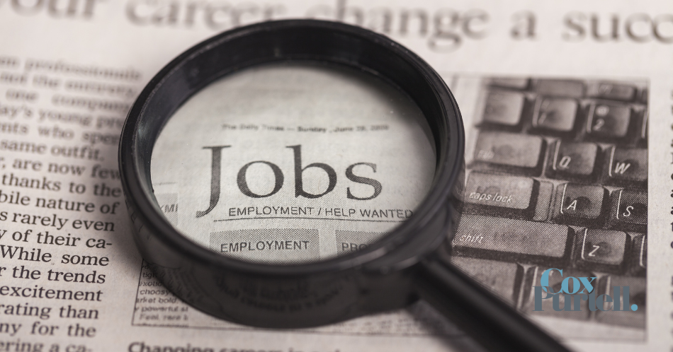 magnifying glass with newspaper job ads
