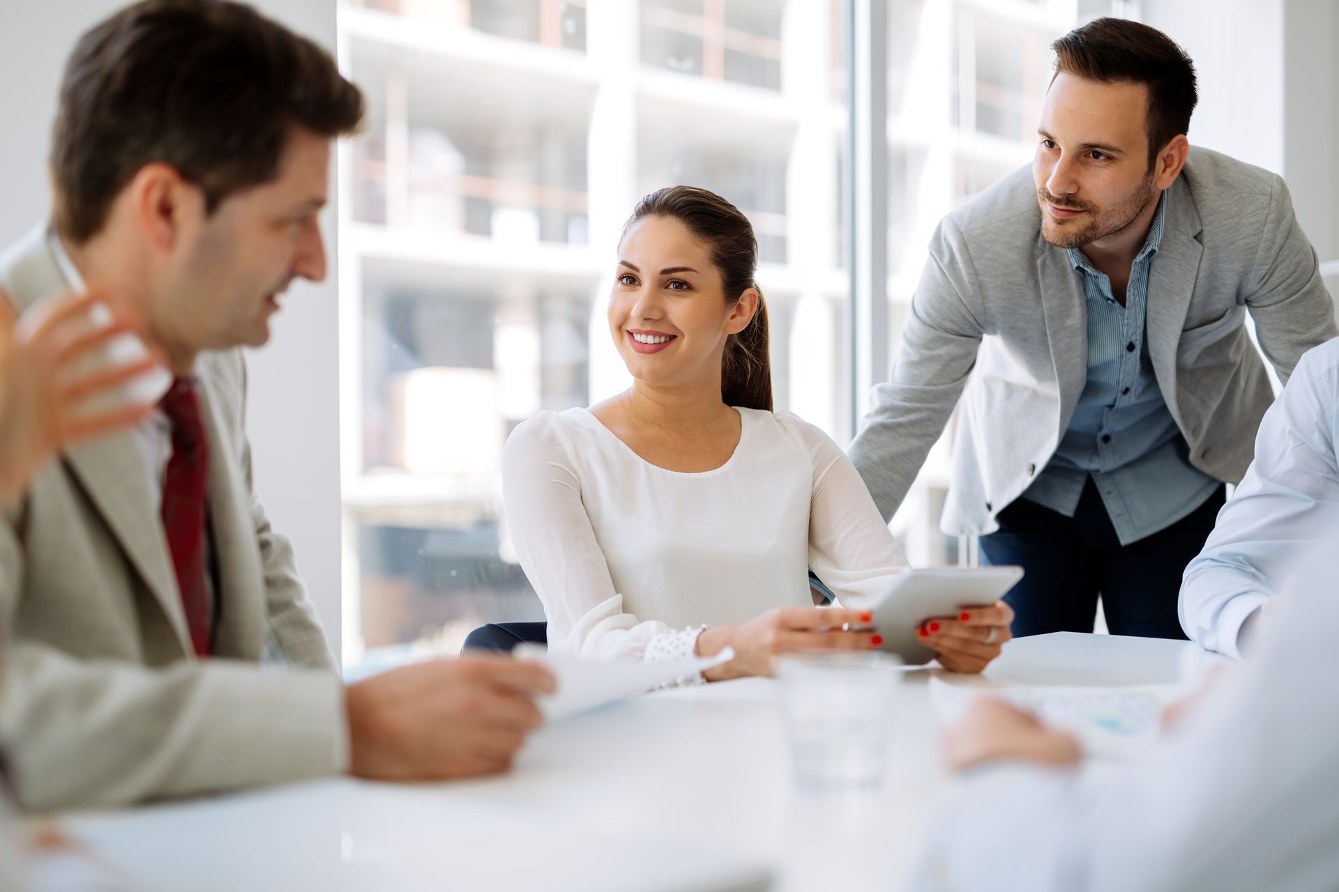 Image of three office workers, two men and one women talking