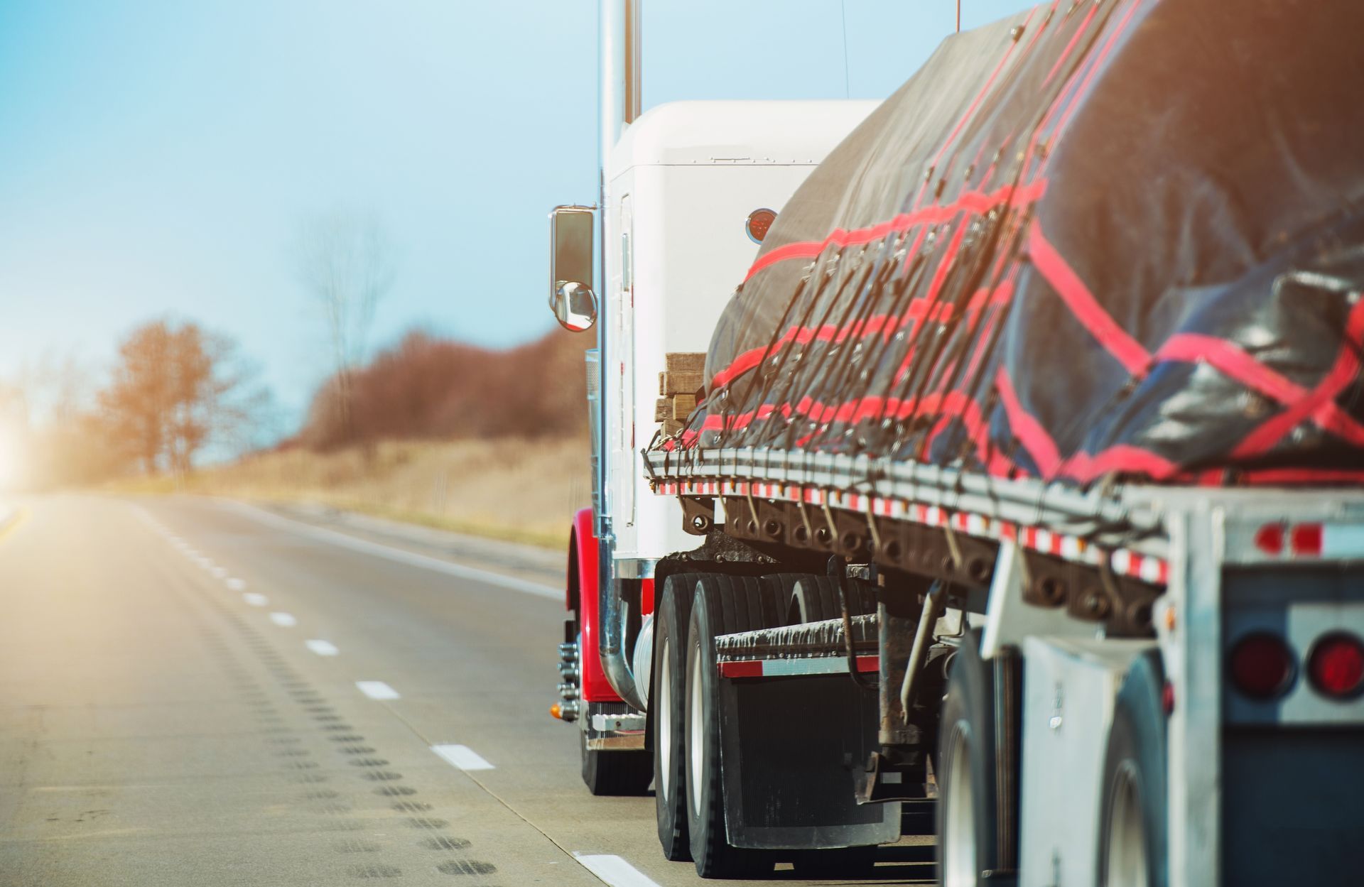 Two semi trucks are driving down a highway.