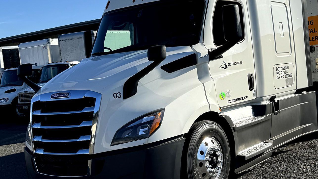 A white semi truck is parked in a parking lot.