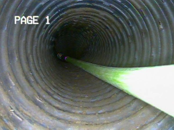 À l'intérieur d'un tuyau nervuré, une ligne verte s'étend dans un tunnel sombre portant l'inscription « PAGE 1 ».