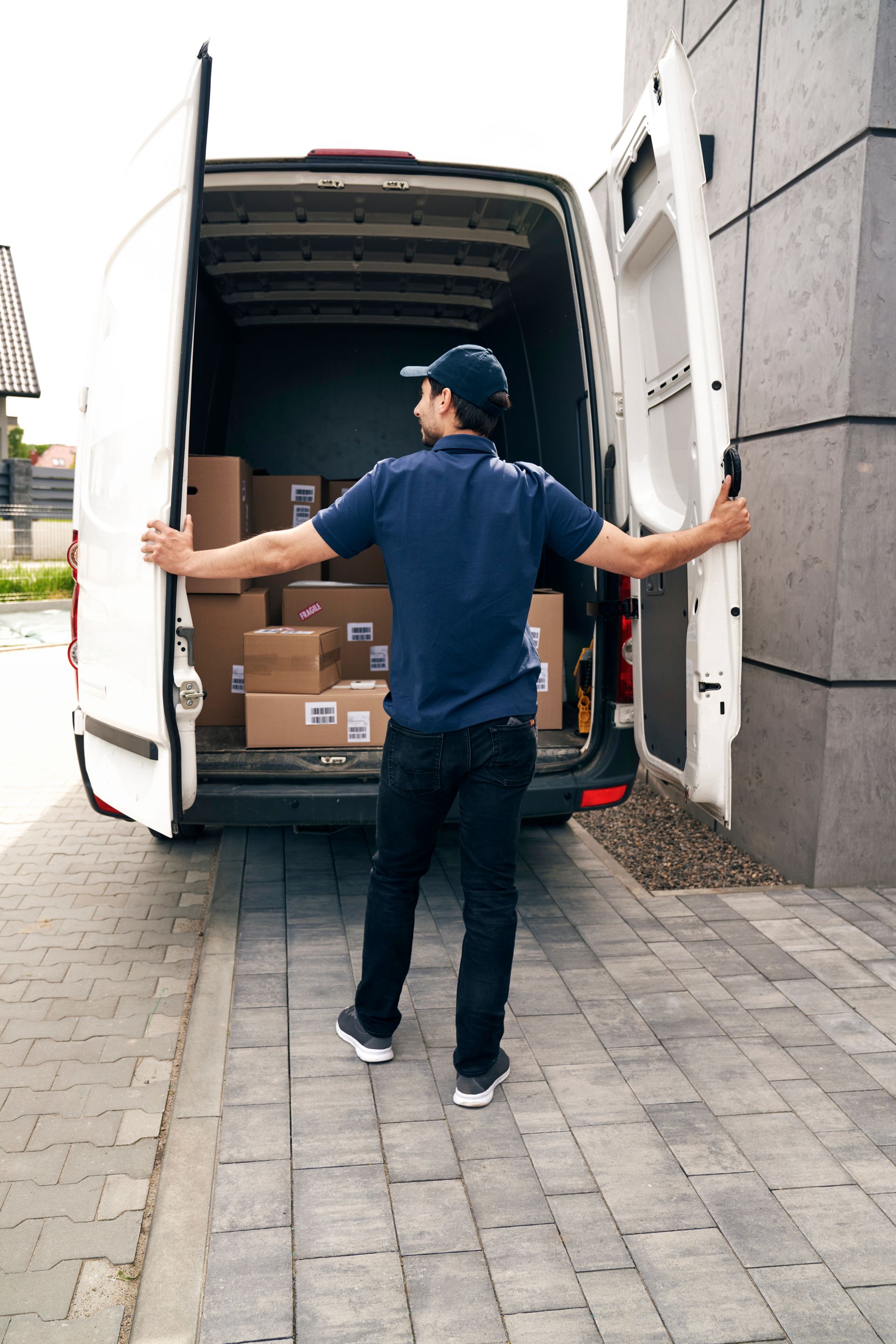 Delivery worker unloading boxes from a truck at a building entrance