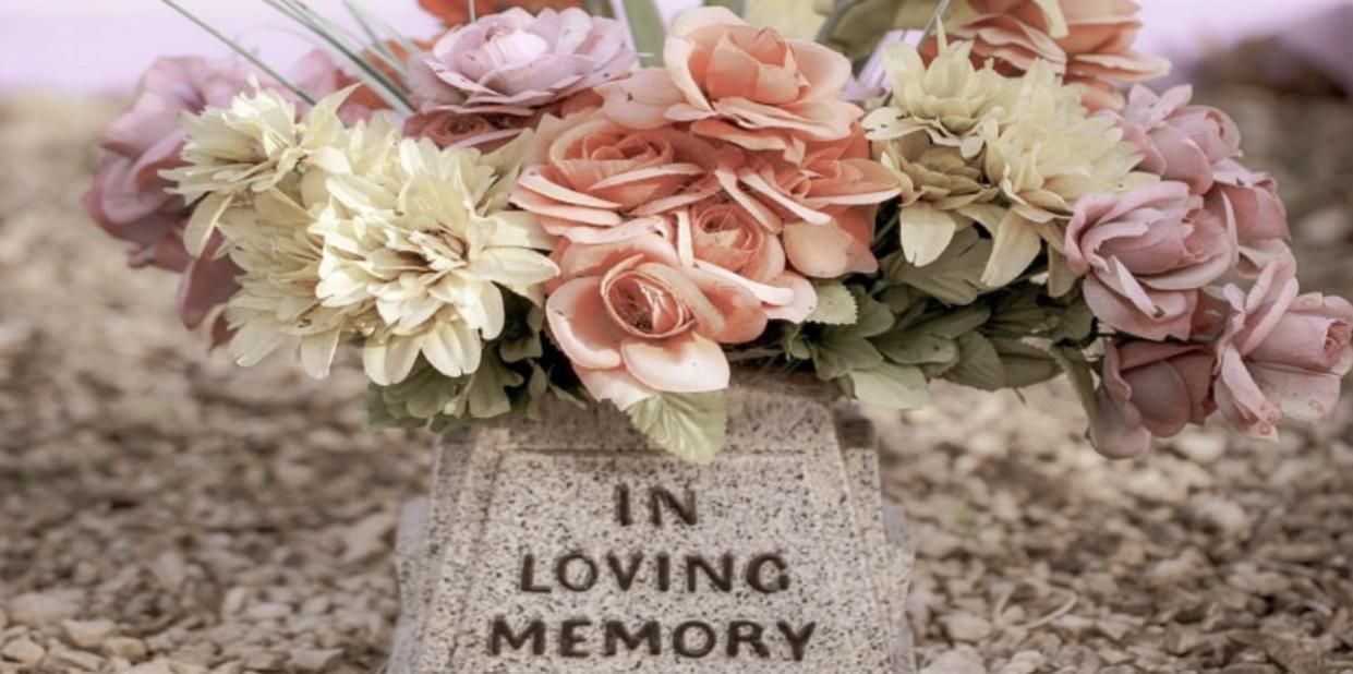 Floral arrangement in a stone vase engraved “In Loving Memory,” symbolizing compassionate Seattle, WA funeral home and cremations services.