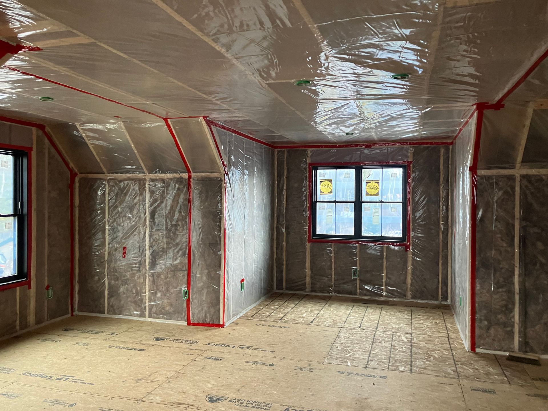 Person installing insulation in a building's walls and ceiling. Person installing insulation in a building's walls and ceiling.