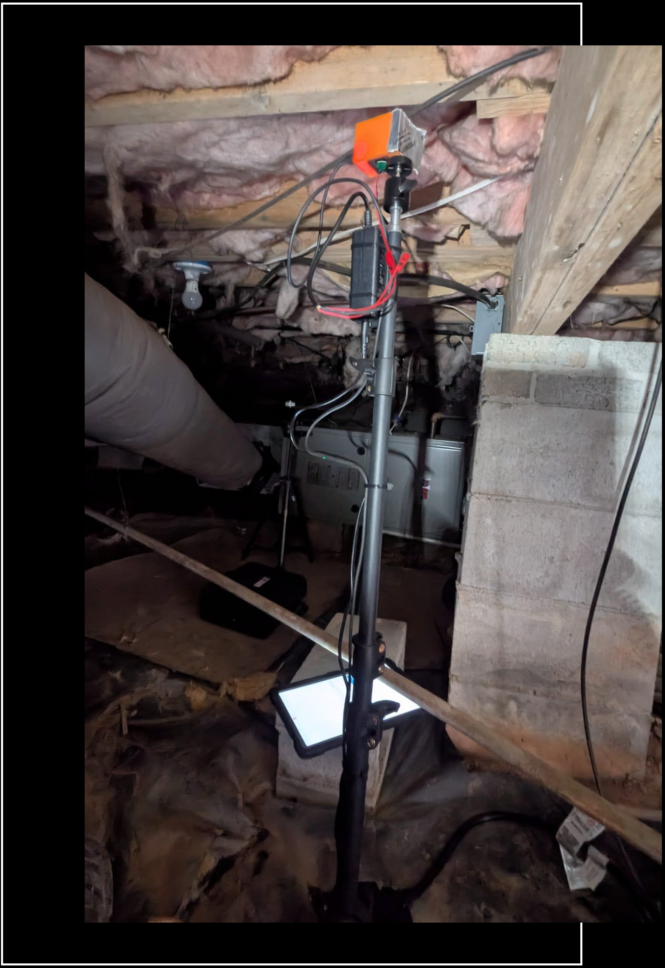 An attic with a lot of wires hanging from the ceiling.