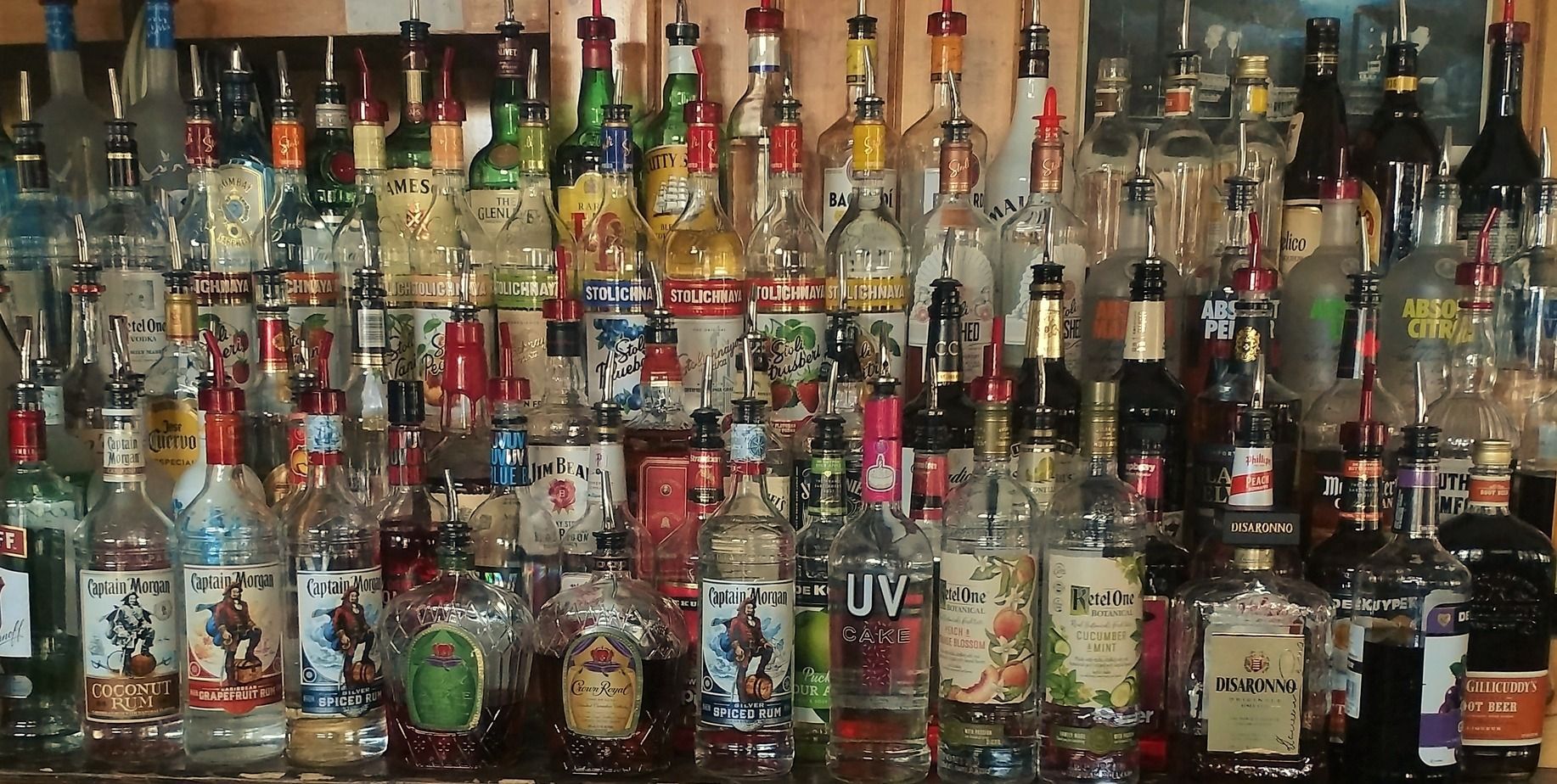 Shelves crowded with assorted liquor bottles and colorful labels in a bar or collection display