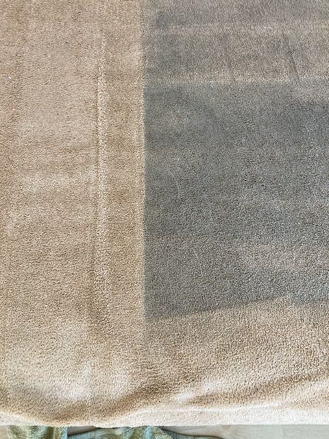 Close-up of a beige fabric surface with a gray rectangular panel and stitched seams.