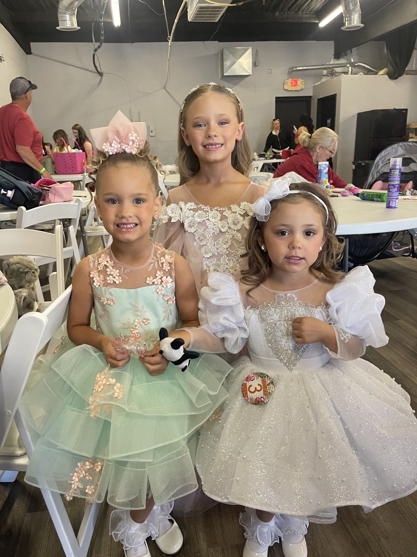 Three girls in fairy costumes posing at a decorated indoor party table.
