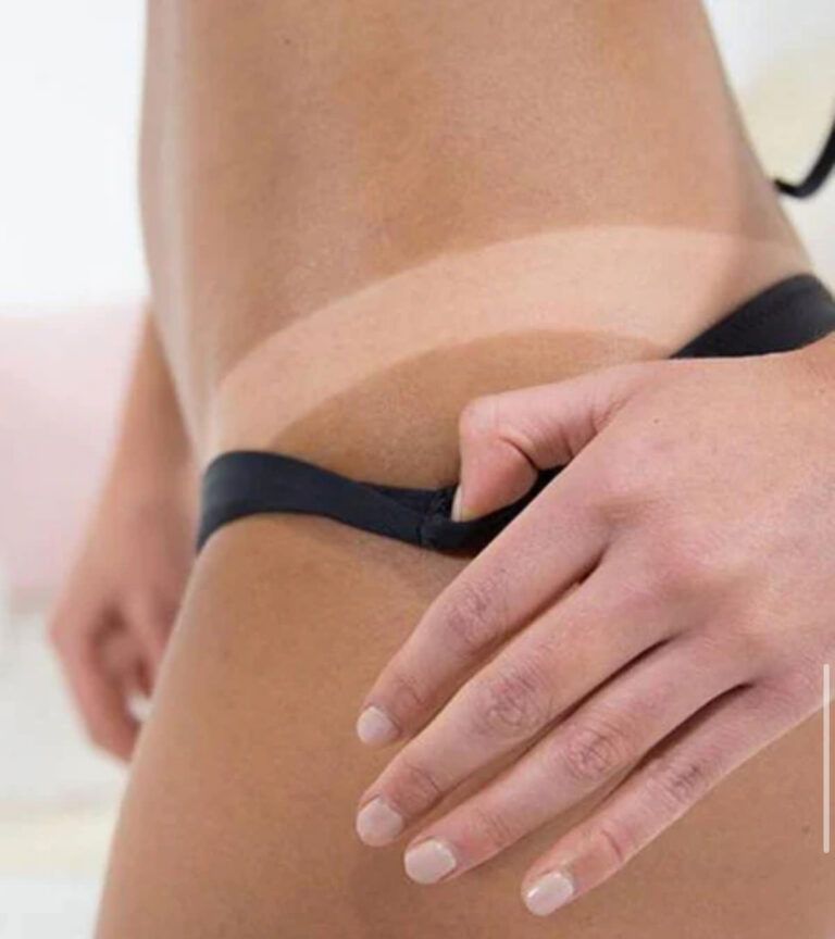 Hand adjusting a black underwear strap at the hip on bare skin