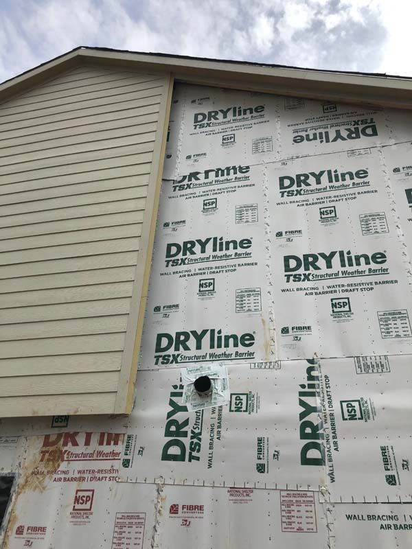 The side of a house is covered in dryline siding.